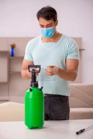 Photo for Young contractor doing pest control at home - Royalty Free Image