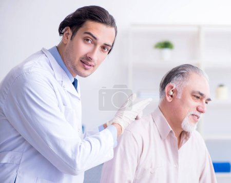 Photo for Male patient with hearing problem visiting doctor otorhinolaryngologist - Royalty Free Image