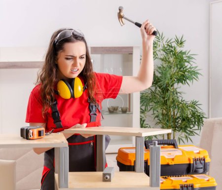 Téléchargez les photos : The female contractor repairing furniture at home - en image libre de droit