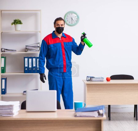Photo for Young contractor disinfecting the office - Royalty Free Image