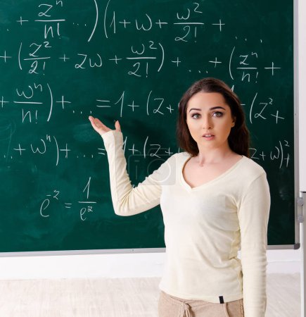 Téléchargez les photos : La jeune enseignante de mathématiques devant un tableau - en image libre de droit