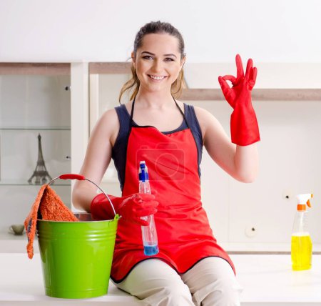 The young beautiful woman cleaning apartment