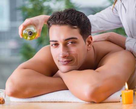 Photo for The handsome man during spa massaging session - Royalty Free Image
