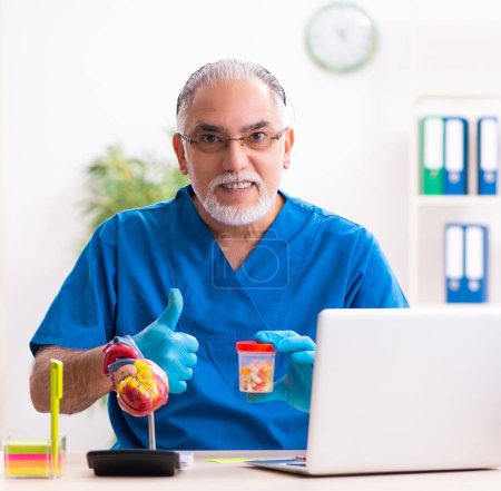 Photo for Old male doctor pharmacist working in clinic - Royalty Free Image