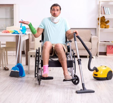 Foto de El joven en silla de ruedas limpiando la casa - Imagen libre de derechos