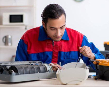 Téléchargez les photos : Le jeune réparateur réparant le climatiseur au centre de garantie - en image libre de droit
