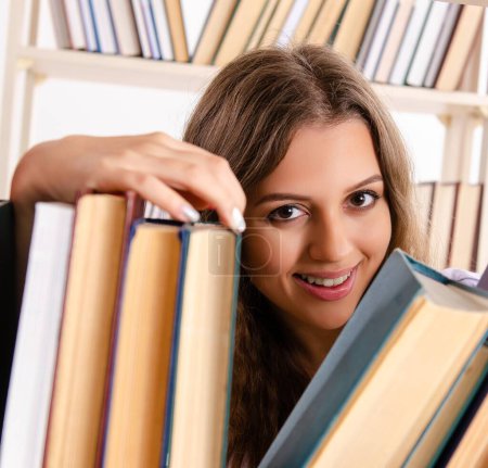 Téléchargez les photos : La jeune étudiante se prépare aux examens à la bibliothèque - en image libre de droit