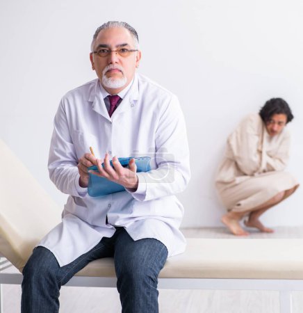 Photo for The aged male doctor psychiatrist examining young patient - Royalty Free Image