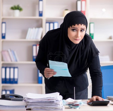 Téléchargez les photos : La femme comptable employée dans le hijab travaillant dans le bureau - en image libre de droit