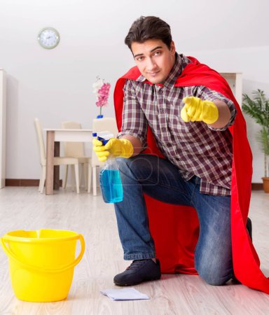 Téléchargez les photos : Le super héros mari nettoyage plancher à la maison - en image libre de droit