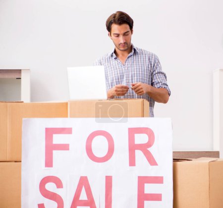 Téléchargez les photos : Le jeune homme offrant la maison à vendre et déménageant - en image libre de droit