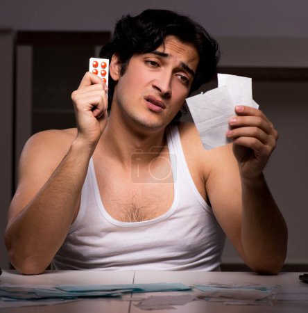 Photo for The young man calculating expences night at home - Royalty Free Image