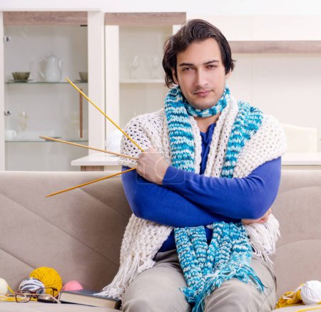 Photo for The young good looking man knitting at home - Royalty Free Image
