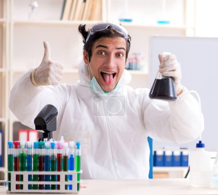 Foto de El joven químico guapo que trabaja en el laboratorio - Imagen libre de derechos