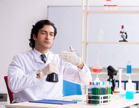 Téléchargez les photos : Le jeune beau chimiste qui travaille au labo - en image libre de droit