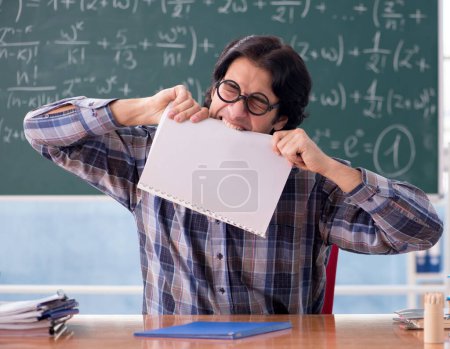 Téléchargez les photos : Le jeune professeur de mathématiques drôle en face du tableau - en image libre de droit