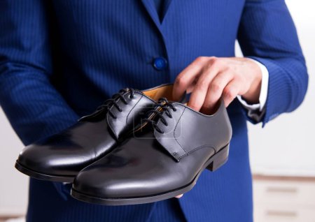 Photo for The young handsome businessman choosing shoes at home - Royalty Free Image