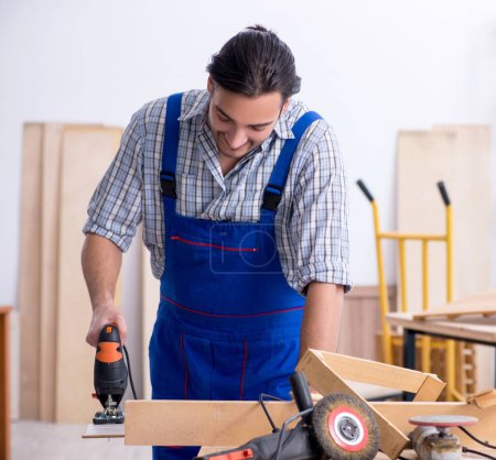 Téléchargez les photos : Le jeune charpentier masculin travaillant à l'intérieur - en image libre de droit