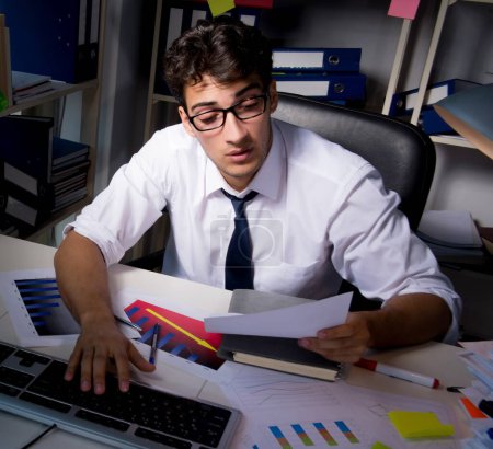 Foto de El hombre de negocios que trabaja hasta tarde en la oficina - Imagen libre de derechos