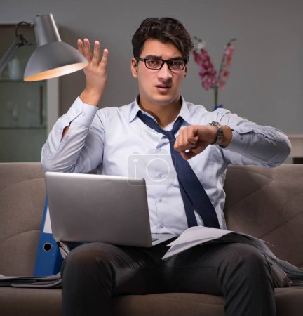 Téléchargez les photos : L'homme d'affaires accro au travail travaillant tard à la maison - en image libre de droit