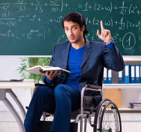 Photo for The young handsome man in wheelchair in front of chalkboard - Royalty Free Image