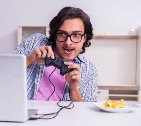 Foto de Estudiante masculino jugando juegos de ordenador en casa - Imagen libre de derechos
