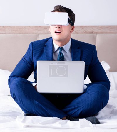 Téléchargez les photos : L'homme d'affaires portant un casque de réalité virtuelle dans la chambre - en image libre de droit
