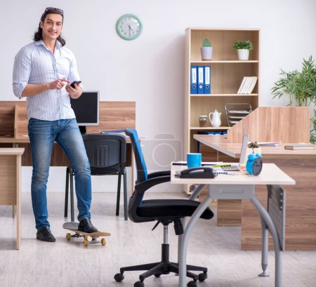 Photo for Young employee with skateboard in the office - Royalty Free Image