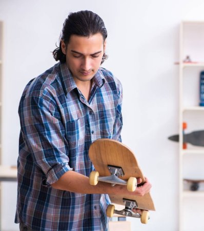 Téléchargez les photos : Homme réparant skateboard à l'atelier - en image libre de droit