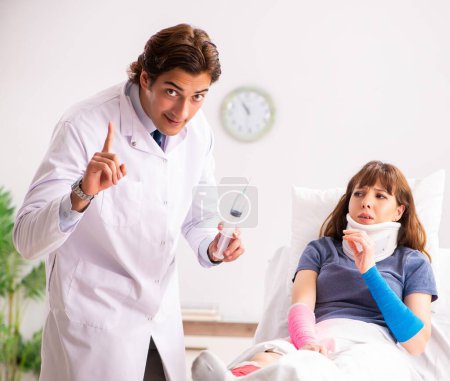 Photo for The young doctor examining injured patient - Royalty Free Image