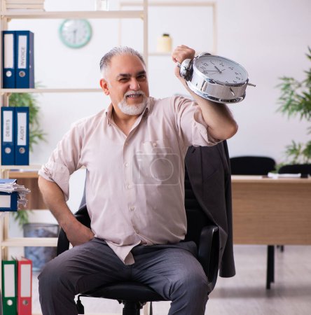 Foto de Hombre mayor empleado haciendo ejercicios físicos en concepto de gestión del tiempo - Imagen libre de derechos