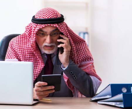 Téléchargez les photos : Vieux comptable arabe extrêmement fatigué avec un travail excessif - en image libre de droit