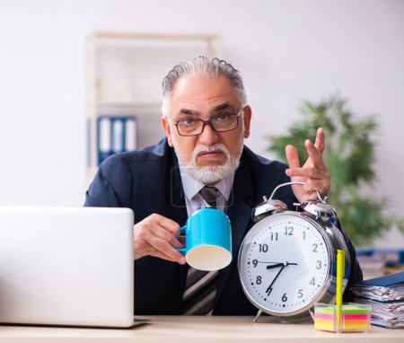 Foto de Viejo empleado masculino bebiendo café en concepto de gestión del tiempo - Imagen libre de derechos