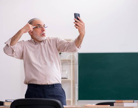 Téléchargez les photos : Vieux professeur devant le tableau noir - en image libre de droit