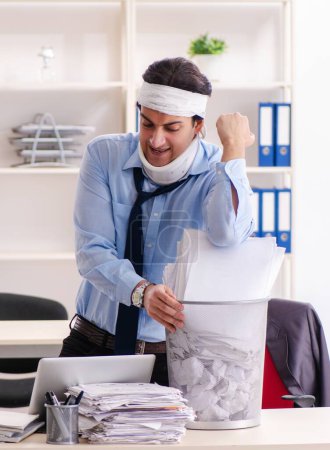 Foto de El joven herido empleado masculino que trabaja en la oficina - Imagen libre de derechos