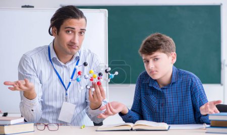 Foto de El joven profesor masculino explicando el modelo molecular - Imagen libre de derechos