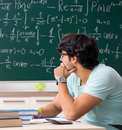 Téléchargez les photos : Le jeune mathématicien étudiant devant le tableau - en image libre de droit