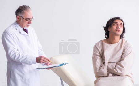 Photo for The aged male doctor psychiatrist examining young patient - Royalty Free Image