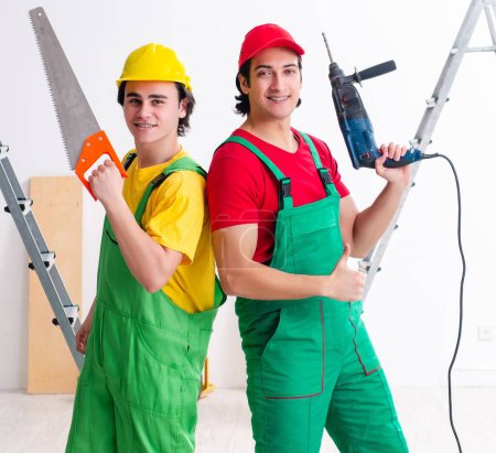Foto de Los dos trabajadores contratistas que trabajan en interiores - Imagen libre de derechos