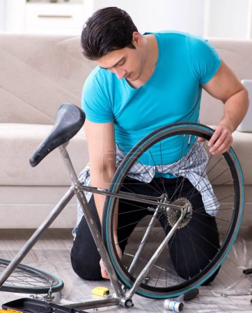 Foto de El joven reparando la bicicleta en casa - Imagen libre de derechos