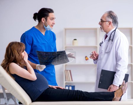 Photo for The two doctors examining young woman - Royalty Free Image