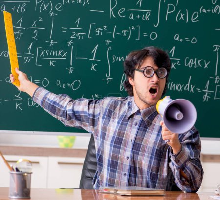 Téléchargez les photos : Le drôle de professeur de mathématiques dans la salle de classe - en image libre de droit