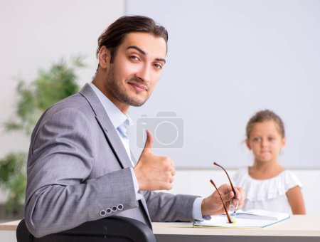Photo for The teacher with young girl in the classroom - Royalty Free Image