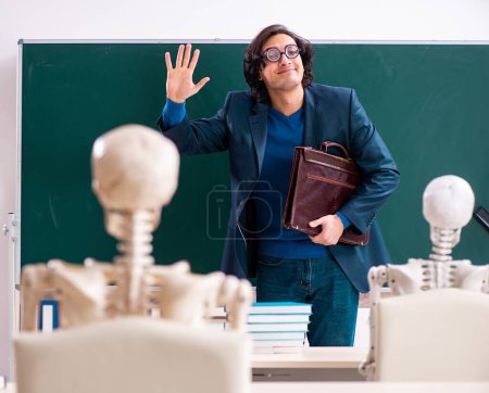 Téléchargez les photos : Le professeur masculin et étudiant squelette dans la salle de classe - en image libre de droit