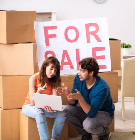 Téléchargez les photos : La jeune famille offrant maison à vendre et déménagement - en image libre de droit