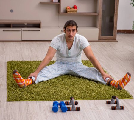 Photo for Young man doing sport exercises indoors - Royalty Free Image