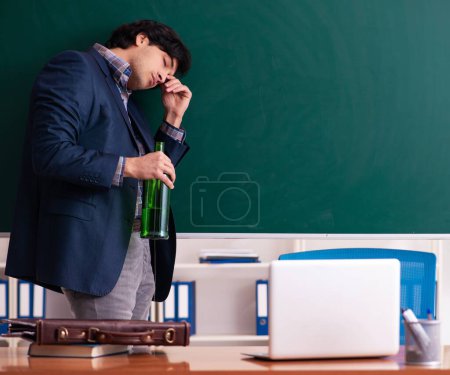 Téléchargez les photos : Le professeur mâle buvant dans la classe - en image libre de droit
