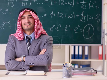 Téléchargez les photos : Le professeur arabe portant un costume devant le tableau - en image libre de droit