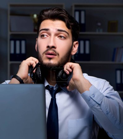 Photo for The young man in call center concept working late overtime in office - Royalty Free Image