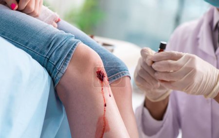 Téléchargez les photos : La jambe blessée jeune femme visitant médecin masculin - en image libre de droit